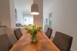 a dining room table with a vase of flowers on it at Meergenuss in Norderney