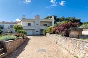 a house with a stone wall and a stone pathway at Villa Montevicoli in Ceglie Messapica