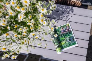 a book sitting on a table next to flowers at Robbenloft in Norderney