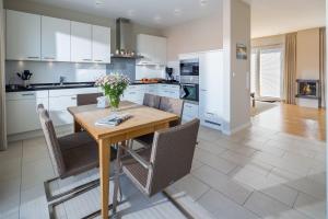 a kitchen with a wooden table and chairs at Robbenloft in Norderney +12 photos