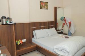 a man is washing a bed in a room at Hotel Rama palace in Mathura