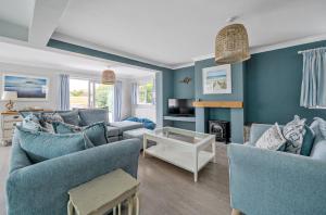 a living room with blue walls and blue furniture at Number Twenty Four in West Wittering