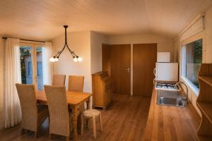 a kitchen with a table and chairs and a refrigerator at Chalet in de Ardennen Comfort & Stilte The Wood in Amblève +16 photos