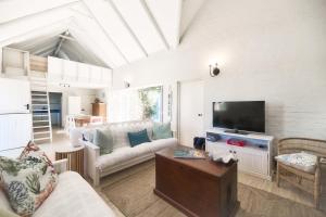 a living room with a couch and a tv at Seafever in Arniston in Arniston