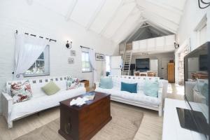 a living room with two white couches and a table at Seafever in Arniston in Arniston