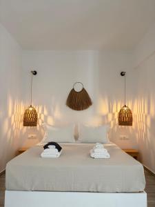 a bedroom with a bed with two towels on it at Eolia luxury suites Andros in Batsi