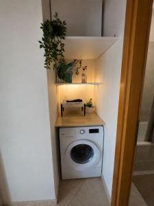 a washer and dryer in a small room with a wall at Apartment Deniz in Nea Peramos
