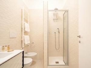 a bathroom with a shower with a toilet and a sink at Terra | 2-Bedroom with Shared Kitchen & Balcony – Seafront Location in Polignano a Mare +14 photos