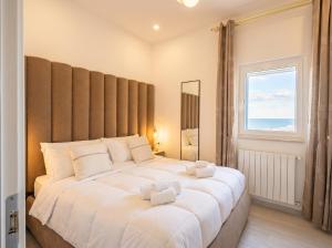 a large white bed in a room with a window at Terra | 2-Bedroom with Shared Kitchen & Balcony – Seafront Location in Polignano a Mare