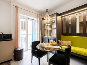 a dining room with a table and a yellow bench at Terra | 2-Bedroom with Shared Kitchen & Balcony – Seafront Location in Polignano a Mare