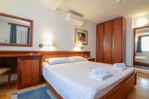 a bedroom with a bed with two towels on it at La porta sul Mare - Apartment Punta in Veli Lošinj +26 photos