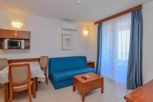 a living room with a blue couch and a table at La porta sul Mare - Apartment Punta in Veli Lošinj