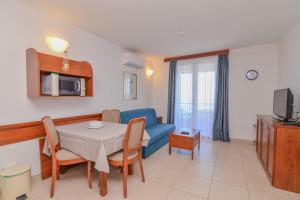 a living room with a table and a blue couch at La porta sul Mare - Apartment Punta in Veli Lošinj