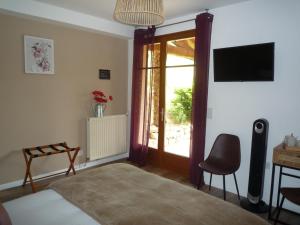 a bedroom with a bed and a sliding glass door at Maison du Pech in Carlux