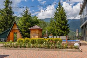 a small wooden building with a garden in front of a building at Vaio Resort in Keda in K'eda
