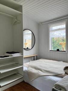 a white bedroom with a bed and a window at Cozy Cabin Iceland in Reynivellir