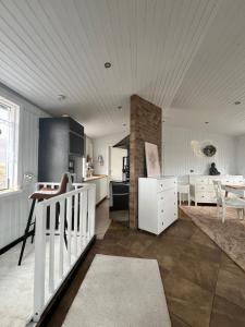 a kitchen and living room with white cabinets and a table at Cozy Cabin Iceland in Reynivellir