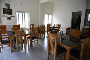 a dining room with wooden tables and chairs at Hotel Uday Villa in Kharsālī