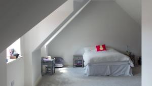 a bedroom with a bed with a red pillow on it at The Clock House in Sacomb