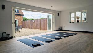 a room with a bunch of yoga mats on the floor at The Clock House in Sacomb