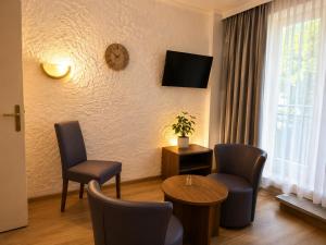 a living room with chairs and a table and a clock at Alpine Studio near Bad Ischl in Bad Ischl +10 photos