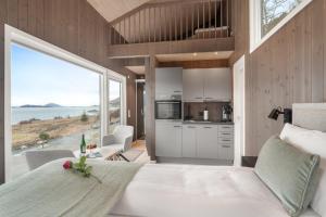 a bedroom with a large white bed and a large window at Kråen Gard in Larsnes