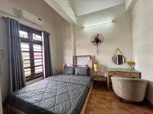 a bedroom with a bed and a desk and a window at Hava Hostel Lang Son in Lạng Sơn