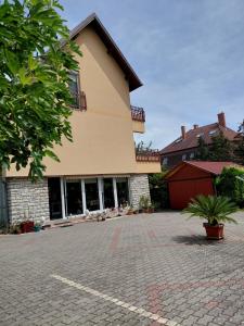 a building with a brick driveway in front of it at KATA VENDÉGHÁZ in Balatonfüred