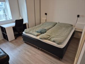 a bed in a room with a desk and a chair at Cosy apartment in Norðskála in Norðskáli