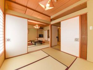 a room with sliding glass doors and a table at Hotel Hagoromo in Shizuoka