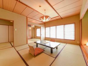 a living room with a table and a chair at Hotel Hagoromo in Shizuoka