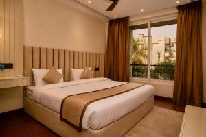 a bedroom with a large bed and a window at Evaara By The Ganges A Ganga Access Resort & Jungle Safari in Haridwār