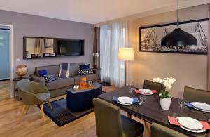 a living room with a dining table and a couch at Citadines Michel Hamburg in Hamburg