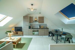 a living room with a table and a kitchen at Logement entier suite balnéo privée in Vierzon