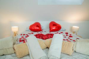 a bed with red pillows and red roses on it at Logement entier suite balnéo privée in Vierzon +16 photos