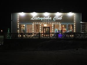 un restaurante iluminado por la noche con luces en Usadba Demidova, en Listvyanka