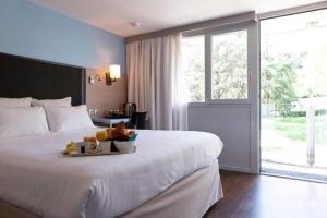 a hotel room with a bed with a tray of food on it at Kyriad Lyon Sud Sainte Foy in Sainte-Foy-lès-Lyon