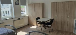 a room with a table and chairs and cabinets at Ferienwohnung in Georgenthal in Georgenthal
