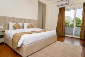 a bedroom with a large bed with a large window at Evaara By The Ganges A Ganga Access Resort & Jungle Safari in Haridwār