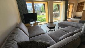 a living room with a couch and a flat screen tv at Ferienwohnung - schof in Tschierv