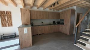 a kitchen with wooden cabinets and a staircase at Ferienwohnung - schof in Tschierv