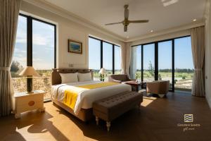a bedroom with a king sized bed and large windows at Golden Sands Golf Resort in Hue +51 photos