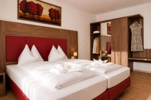 a bedroom with a large white bed with white pillows at Gästehaus Munk in Günzburg