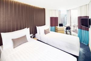 a hotel room with two beds and a desk at Hotel 108, Hong Kong in Hong Kong
