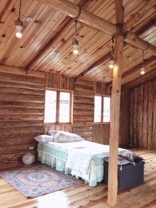 ein Schlafzimmer mit einem Bett in einer Holzhütte in der Unterkunft Agape Log Cabin in Sagada