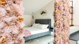 a room with a bed and a wall of flowers at Aetna LuxurySuites in Catania