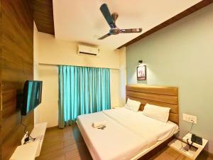 a bedroom with a bed and a flat screen tv at Fortune Resort in Alībāg +107 photos