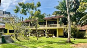 a yellow building with trees in front of it at Muthukirula Resort in Aluthgama +20 photos