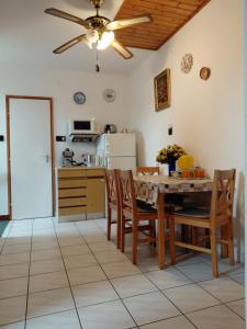 a kitchen with a table and chairs and a ceiling fan at KATA VENDÉGHÁZ in Balatonfüred