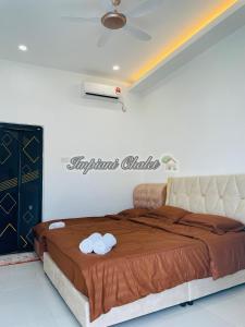 a bedroom with a bed with two towels on it at Impiani Chalet with Private Pool in Kuala Terengganu